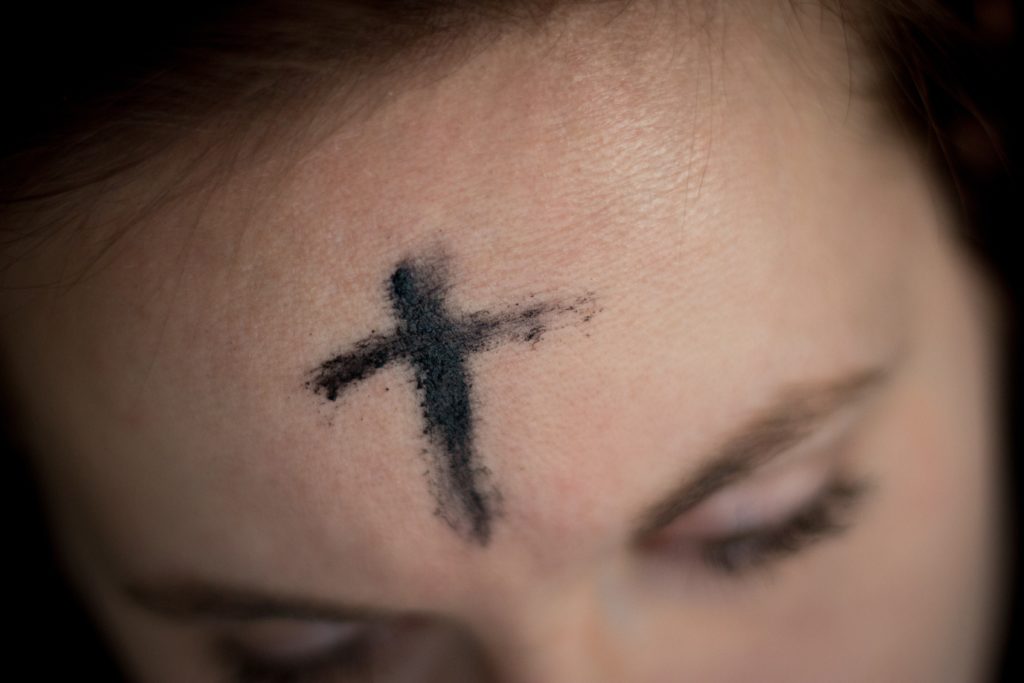 Woman wish Ash Wednesday cross on her face.